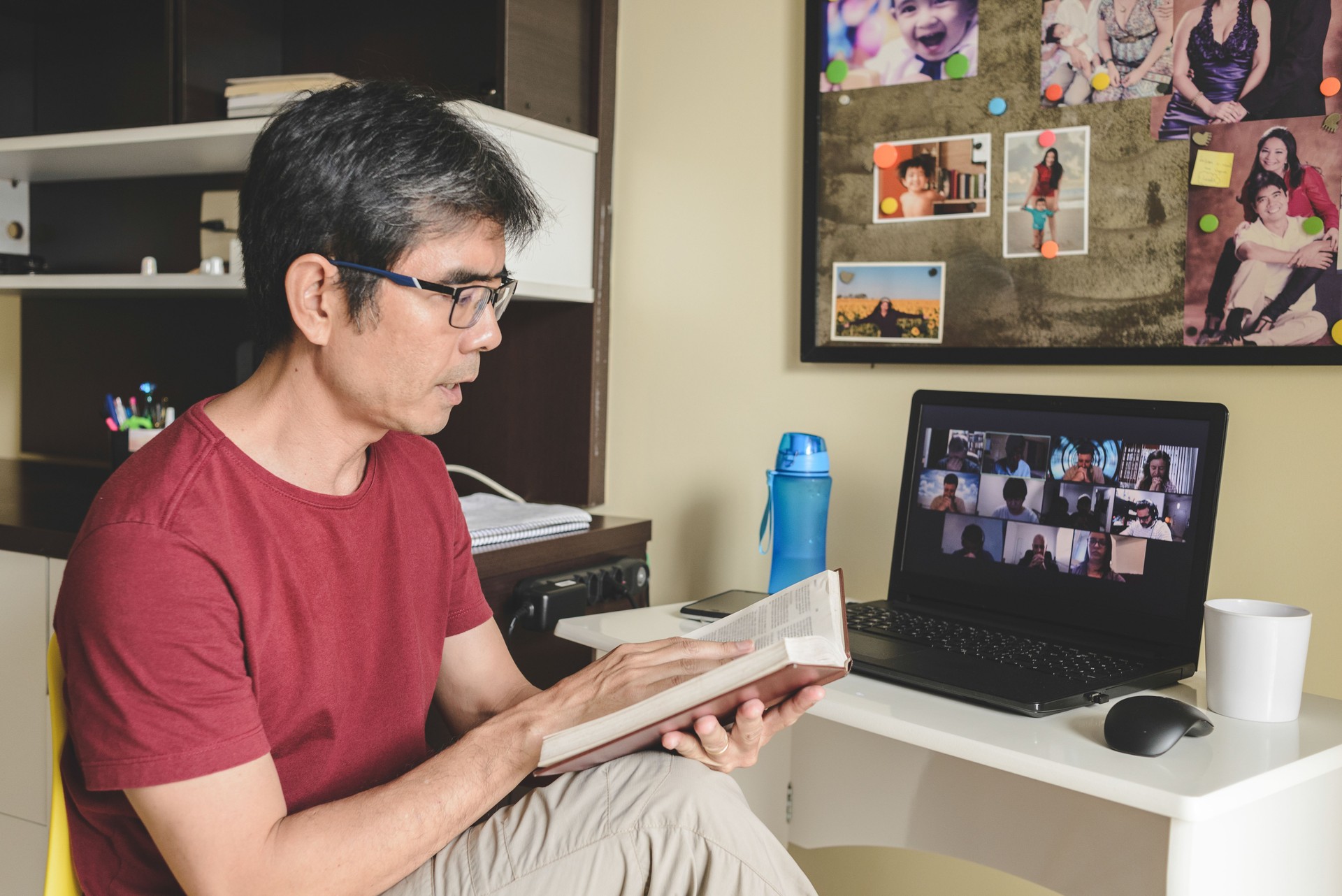 Man at home joining a group of people online praying together in a video conference